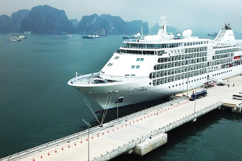 A large cruise ship docked at a pier in Ha Long Bay, Vietnam
