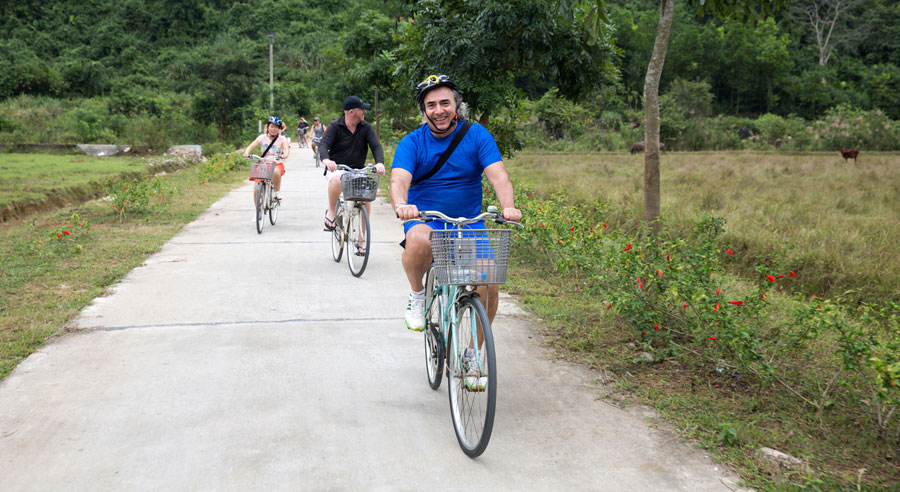 Group of tourists enjoying a scenic bike ride through the countryside near Ha Long Bay