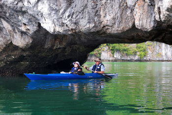 Kayaking adventure through caves on Ha Long Bay with the Orchid Trendy Cruise, Vietnam - An exciting outdoor activity for all ages