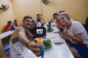 Tourists taking a group selfie in Hanoi, enjoying the vibrant nightlife and local attractions.