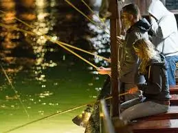 Tourists enjoying squid fishing at night in Ha Long Bay